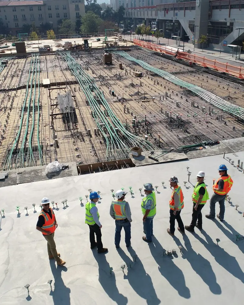 Equipe de trabalhadores da construção civil sobre uma laje em obra